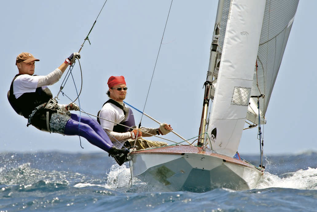 Two sailors pilot an International Fireball racing sailboat with trapeze rigging.