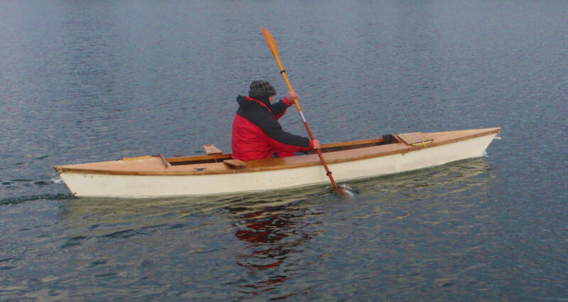 Pirogue with man and double-bladed paddle